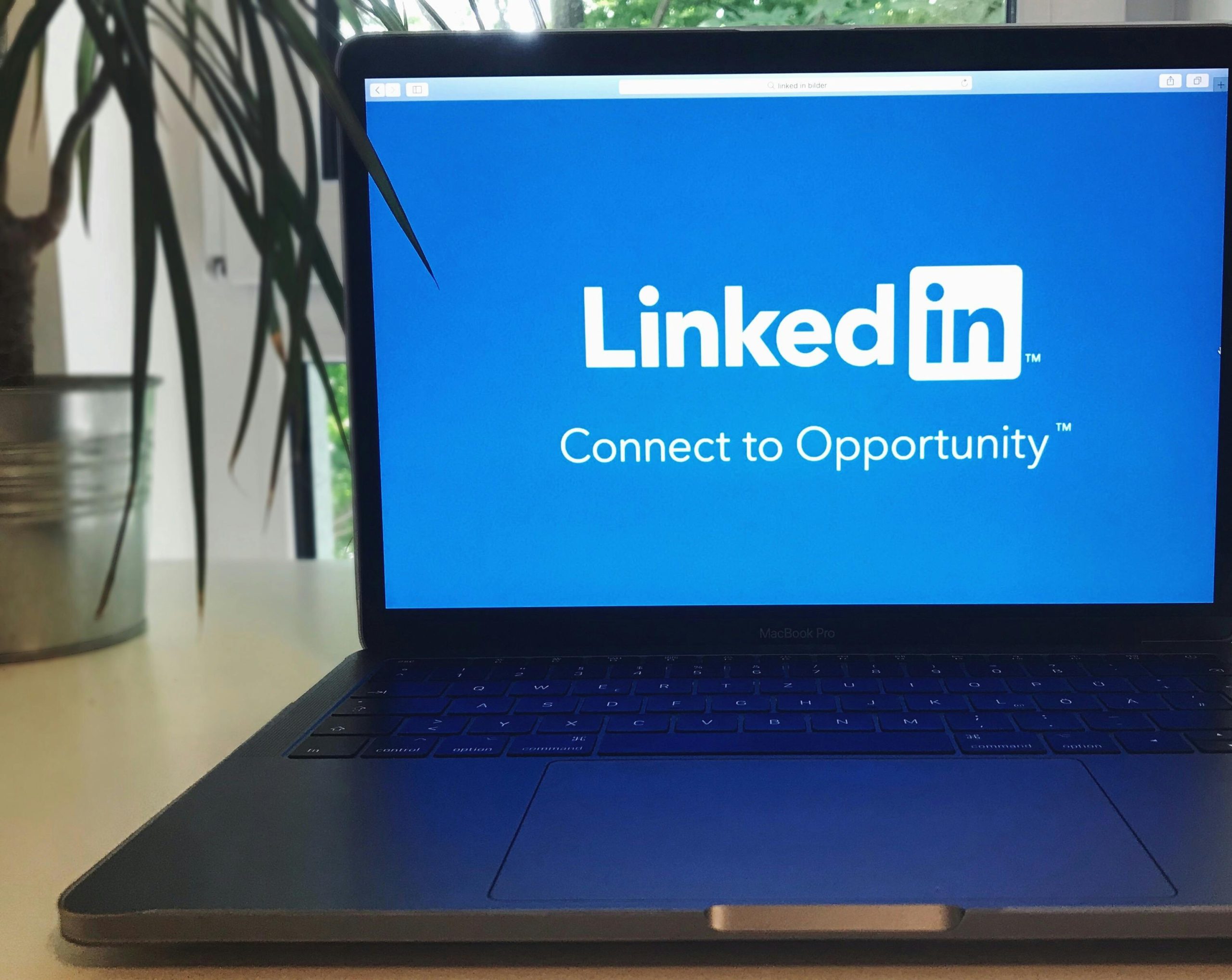 A laptop screen displaying the LinkedIn logo with the text 'Connect to Opportunity'.