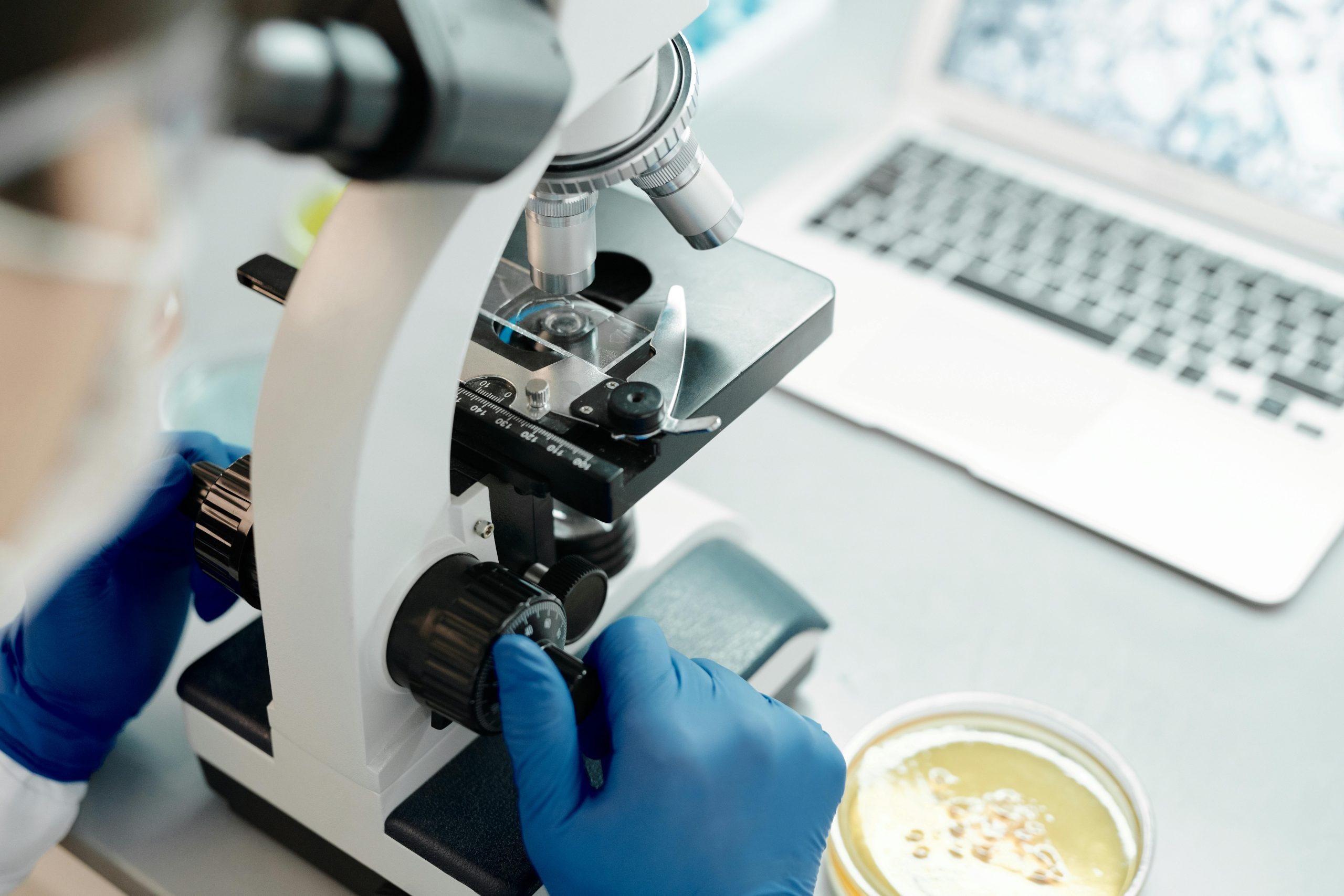 Researcher analyzing biological samples under a microscope in a laboratory.