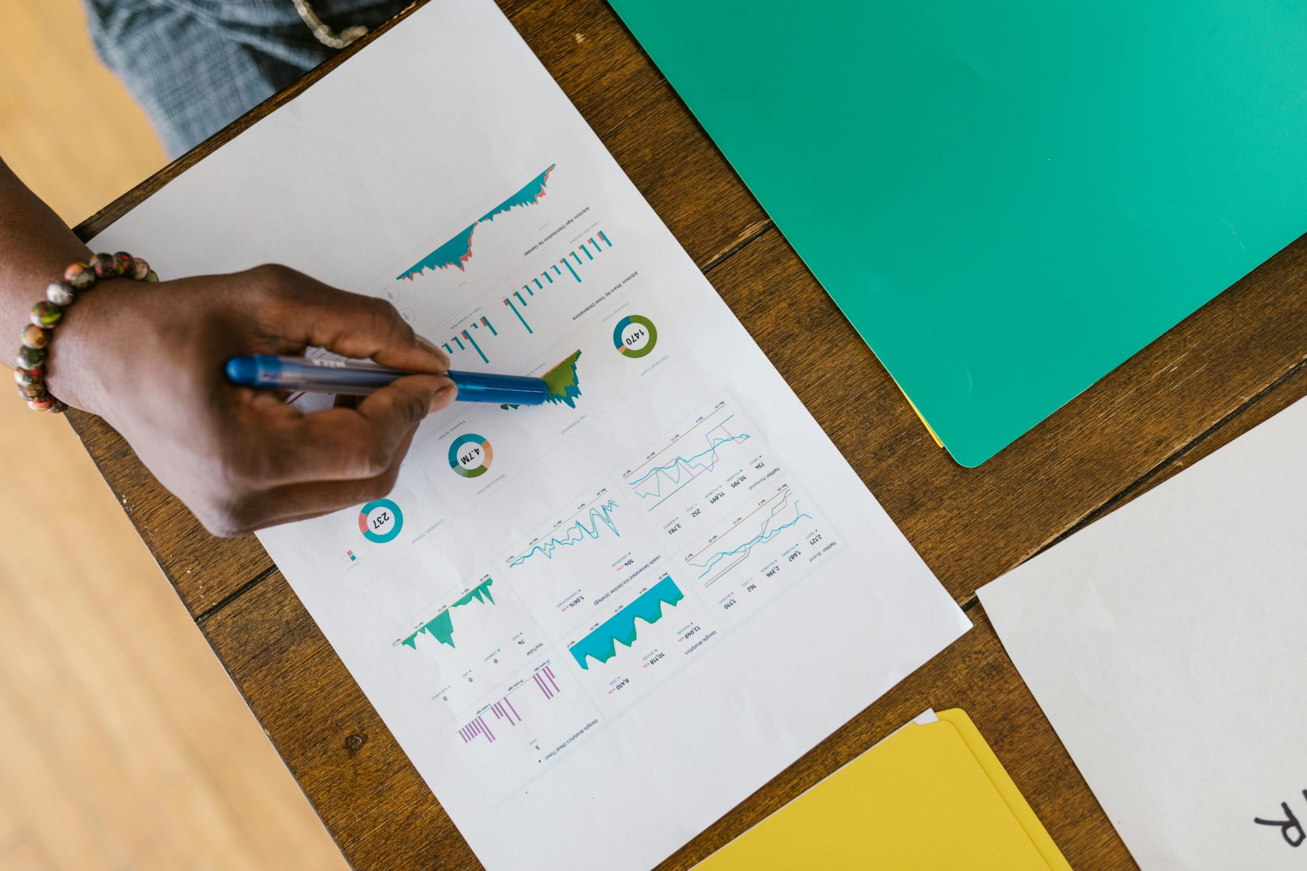 Overhead view of a person analyzing business charts and graphs on paper.